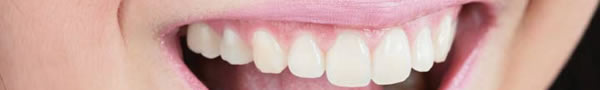 A client of Lake Forest Dental with beautiful teeth smiling to show off her cosmetic dentures